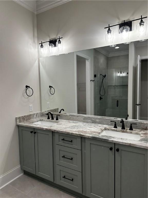 489 Windsor Dr, Opelika, AL 36801 - bathroom featuring crown molding, a shower stall, double vanity, and tile patterned flooring