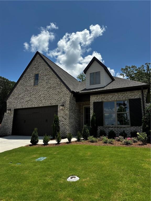 489 Windsor Dr, Opelika, AL 36801 - view of front of house featuring a front yard, brick siding, concrete driveway, and a garage