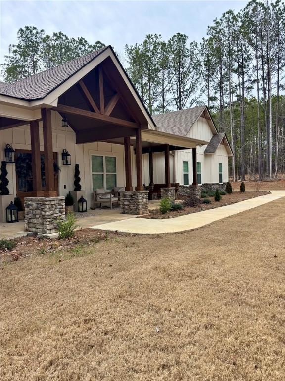 exterior space with roof with shingles and board and batten siding