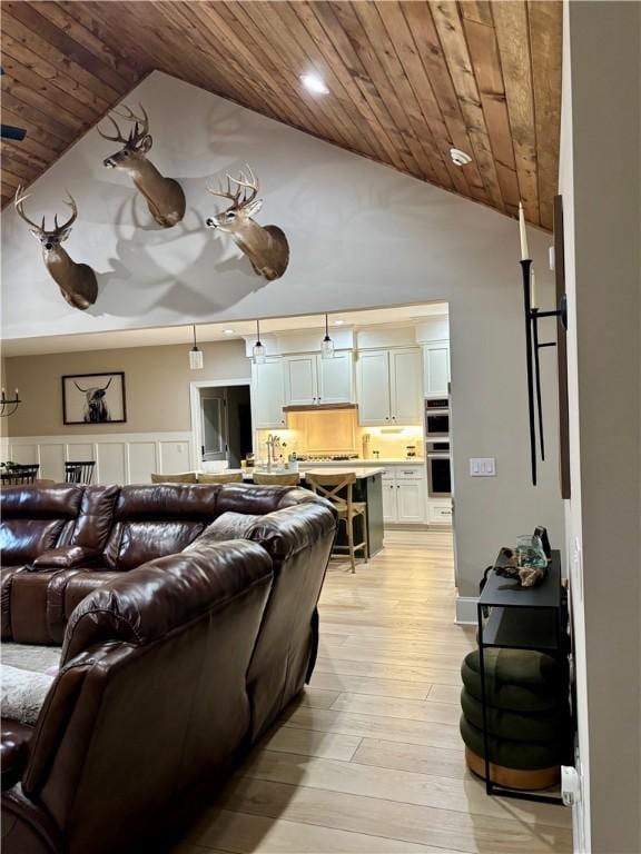 living room featuring high vaulted ceiling, light wood-type flooring, and wood ceiling