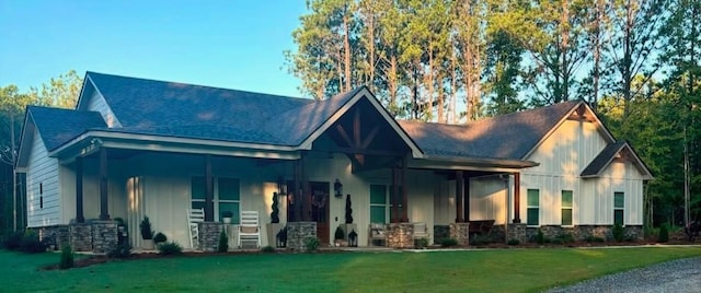 view of front of home featuring covered porch, roof with shingles, and a front yard