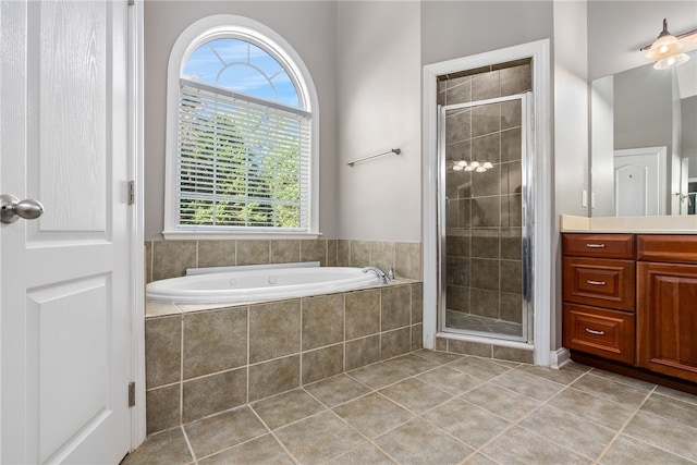 bathroom with tile patterned flooring, vanity, and separate shower and tub