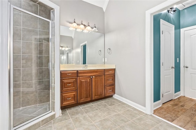 full bathroom featuring tile patterned floors, baseboards, a shower stall, and vanity