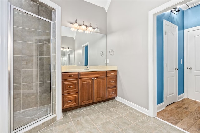 bathroom featuring tile patterned flooring, vanity, and a shower with shower door