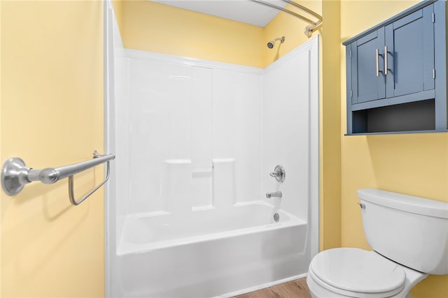 bathroom with bathtub / shower combination, wood-type flooring, and toilet