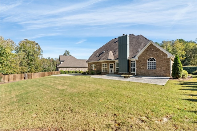 back of house with a yard and a patio