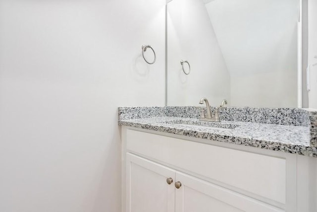 bathroom featuring vanity and lofted ceiling