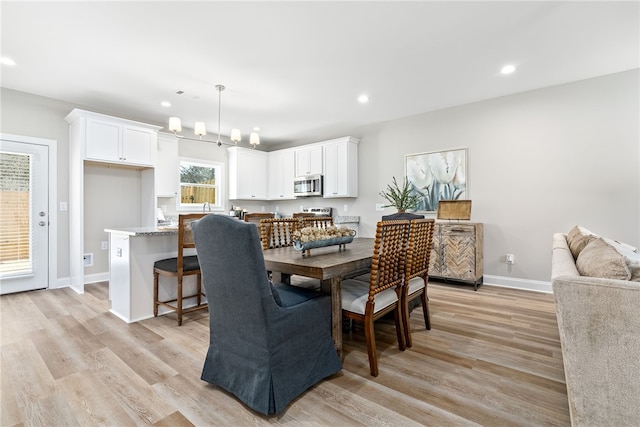 dining space featuring light wood finished floors, baseboards, visible vents, and recessed lighting