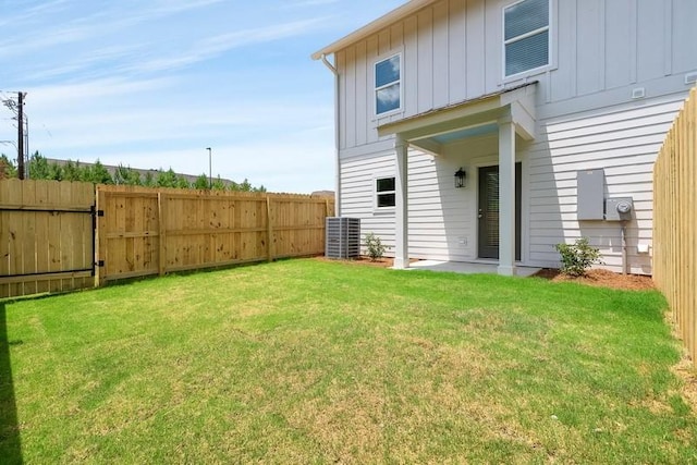 back of property with central air condition unit and a lawn