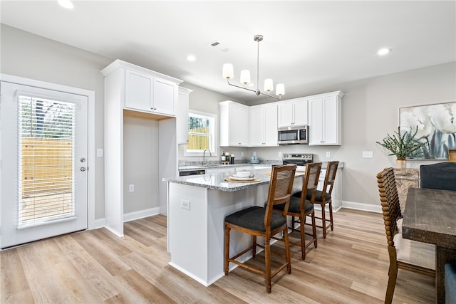 kitchen featuring white cabinetry, light wood-style flooring, a sink, and stainless steel appliances