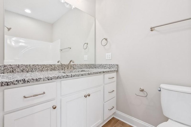 bathroom featuring wood-type flooring, vanity, and toilet