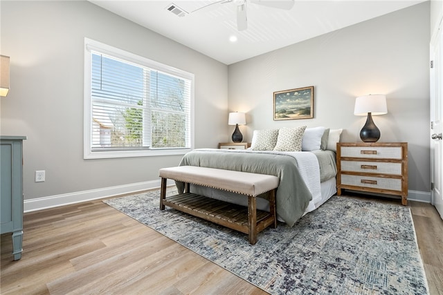 bedroom with baseboards, visible vents, wood finished floors, and a ceiling fan