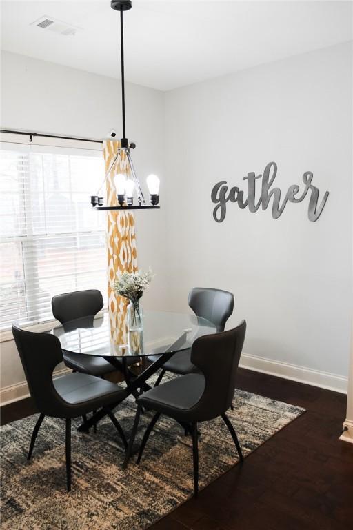 dining area featuring dark hardwood / wood-style floors and a notable chandelier