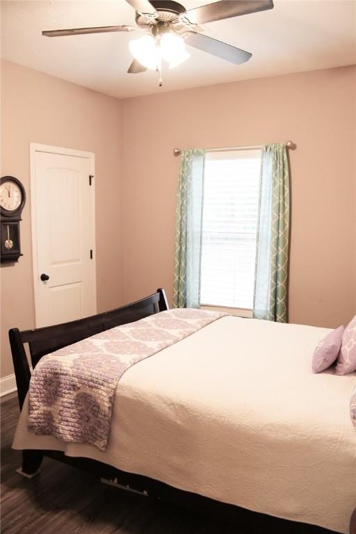 bedroom with dark hardwood / wood-style flooring and ceiling fan