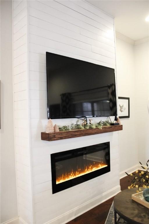 room details featuring hardwood / wood-style flooring, ornamental molding, and a fireplace