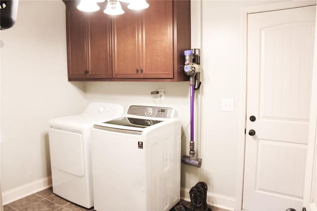 laundry area featuring separate washer and dryer, tile patterned floors, and cabinets