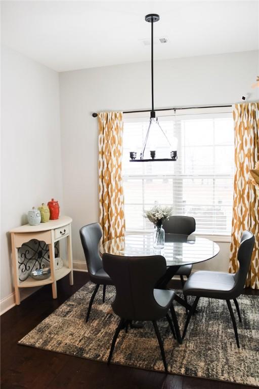 dining space with hardwood / wood-style flooring and a chandelier