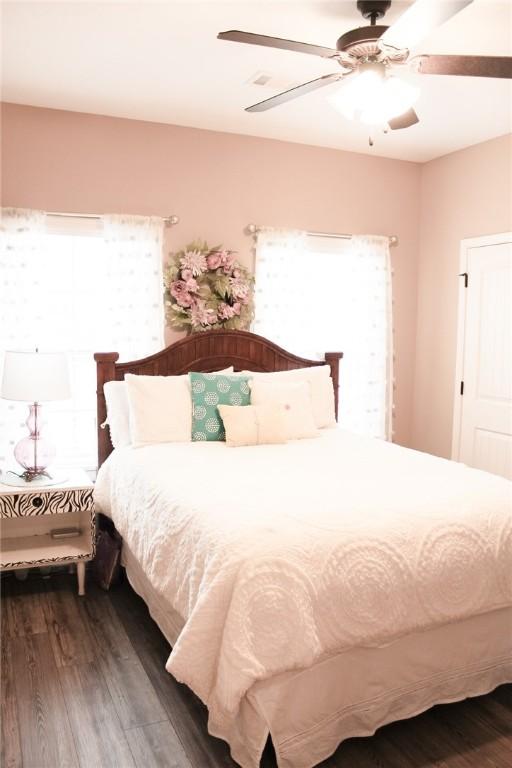 bedroom with dark hardwood / wood-style floors and ceiling fan