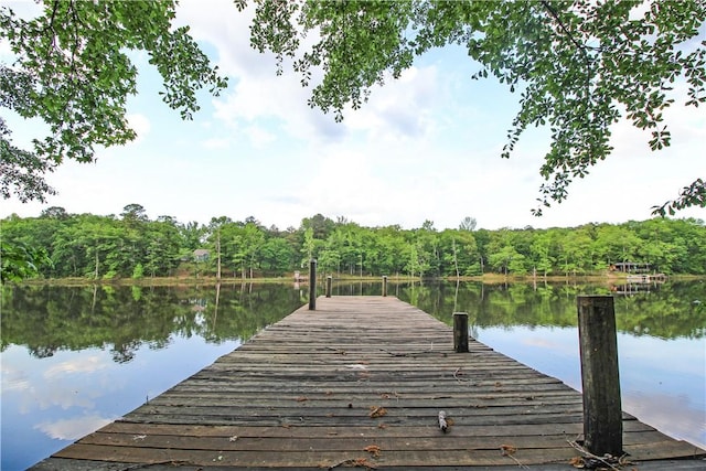 dock area with a water view and a wooded view