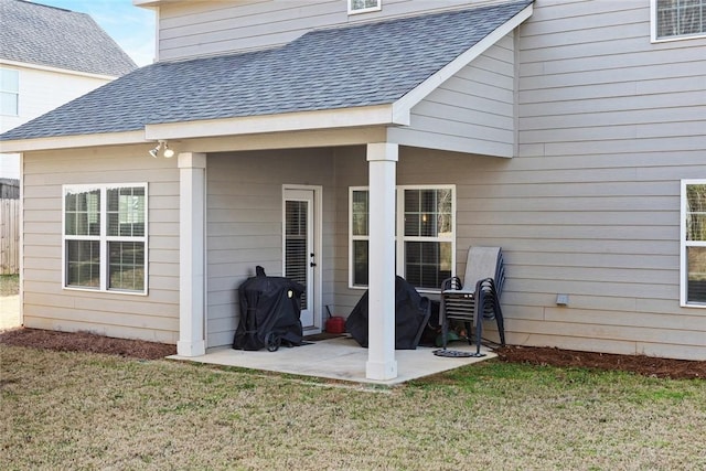 exterior space with a yard, a patio area, and roof with shingles