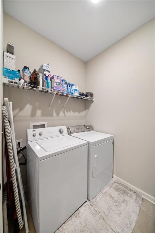 laundry room with baseboards, laundry area, and washing machine and clothes dryer