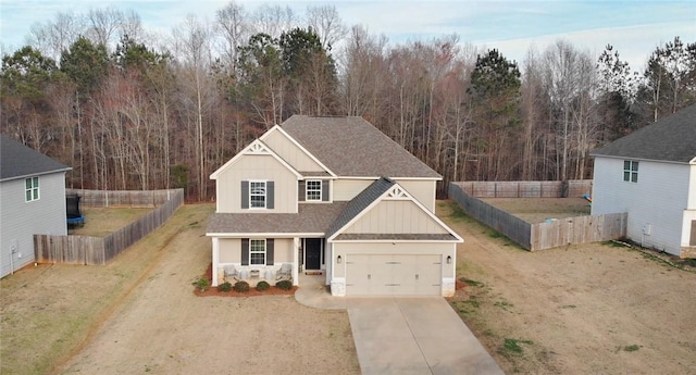 traditional home featuring fence, board and batten siding, concrete driveway, a front yard, and a shingled roof