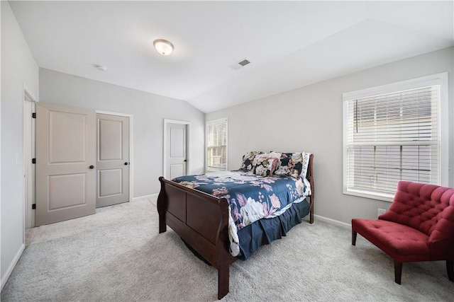 carpeted bedroom with vaulted ceiling, visible vents, and baseboards