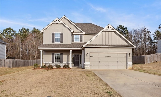 craftsman house featuring stone siding, board and batten siding, concrete driveway, and fence