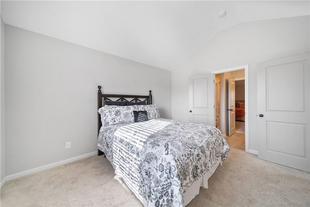 bedroom with vaulted ceiling, baseboards, and light carpet