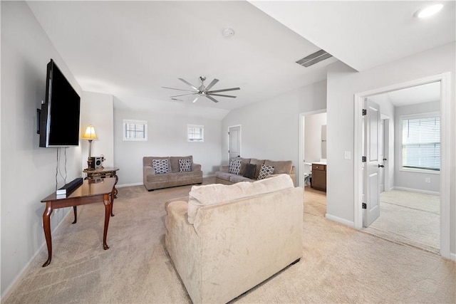 living area with baseboards, light colored carpet, and ceiling fan