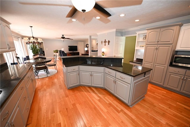 1765 Creekwood Trl, Auburn, AL 36830 - kitchen with a ceiling fan, stainless steel microwave, light wood finished floors, a center island, and open floor plan