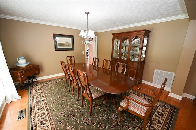 1765 Creekwood Trl, Auburn, AL 36830 - dining space featuring a chandelier, wood finished floors, ornamental molding, and a textured ceiling