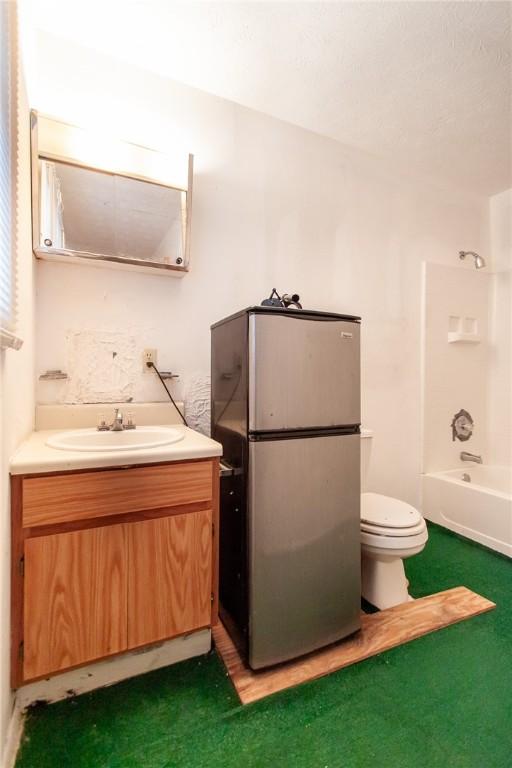 full bathroom with toilet, vanity, and washtub / shower combination