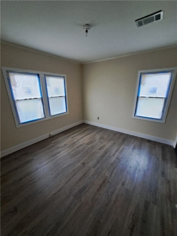 unfurnished room with crown molding and dark wood-type flooring