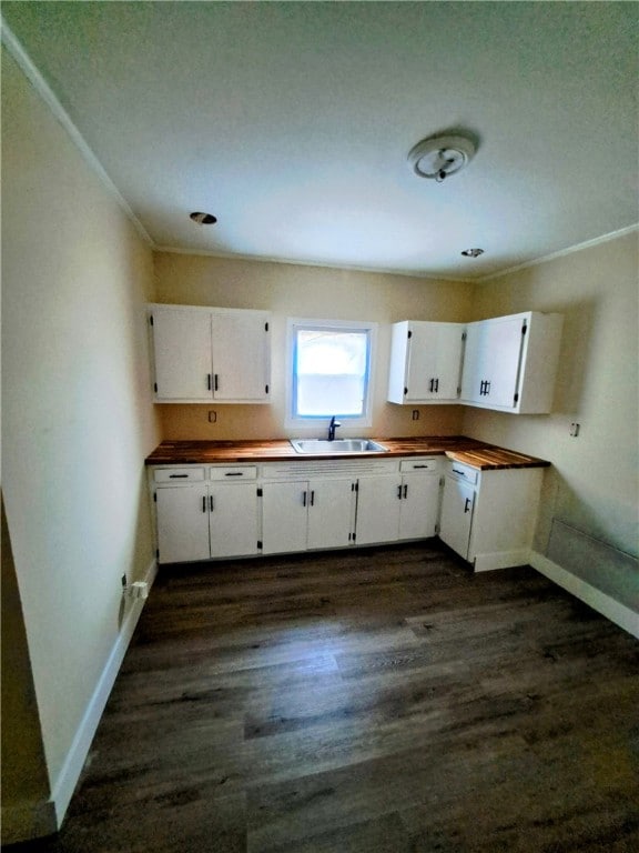 kitchen with crown molding, sink, white cabinets, and dark hardwood / wood-style flooring