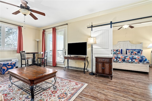 living room with ornamental molding, wood finished floors, baseboards, and a ceiling fan