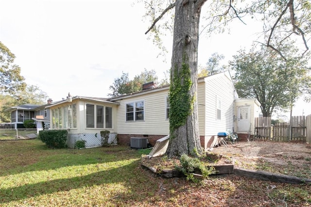 rear view of house featuring a lawn and a sunroom