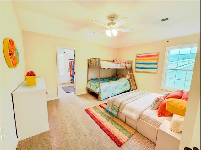 carpeted bedroom featuring ceiling fan, baseboards, and ensuite bathroom