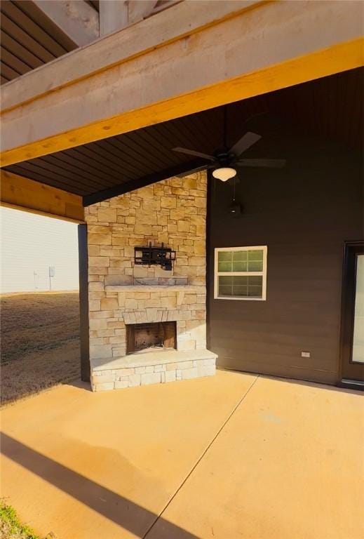 view of patio featuring a fireplace and ceiling fan