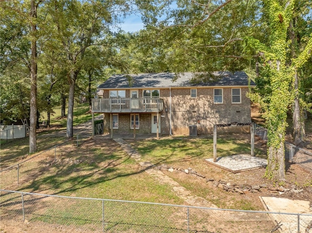 rear view of property featuring a yard and a wooden deck
