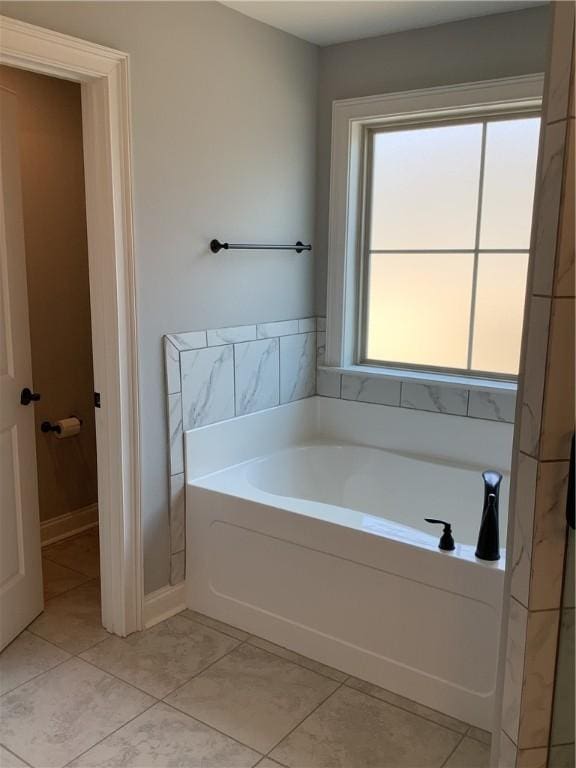 full bathroom with a garden tub and tile patterned flooring
