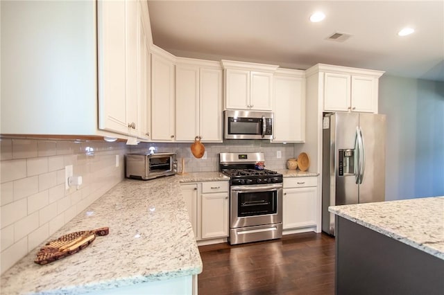 2647 Dunkirk Cir, Auburn, AL 36832 - kitchen featuring stainless steel appliances, decorative backsplash, dark wood-style flooring, light stone countertops, and recessed lighting