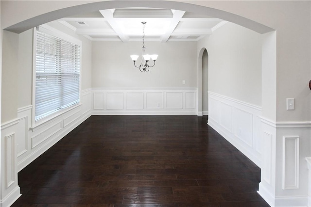 unfurnished dining area with coffered ceiling, beam ceiling, dark wood-type flooring, and an inviting chandelier