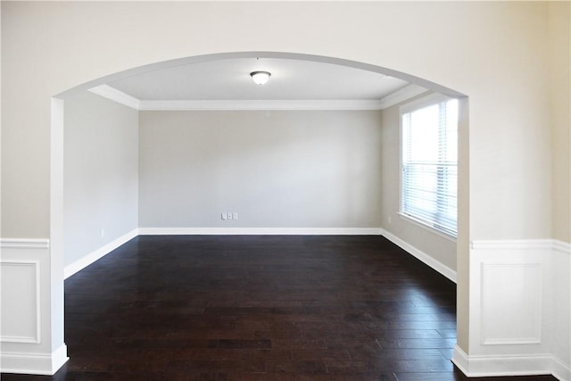 spare room featuring dark hardwood / wood-style flooring and ornamental molding