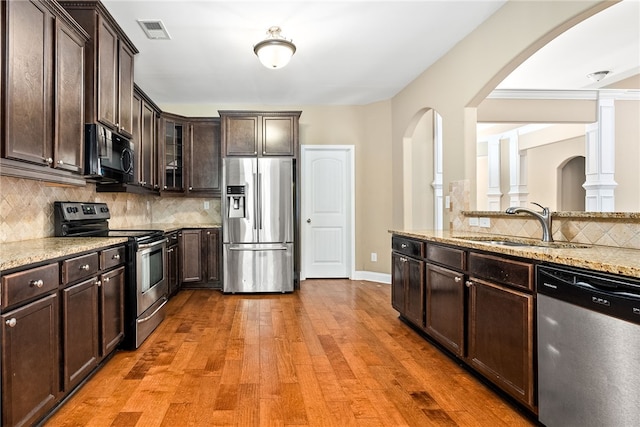 2316 Tuscany Pl, Auburn, AL 36830 - kitchen featuring a sink, appliances with stainless steel finishes, visible vents, dark brown cabinetry, and arched walkways