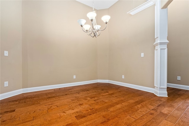 2316 Tuscany Pl, Auburn, AL 36830 - empty room featuring baseboards, wood finished floors, an inviting chandelier, and ornate columns