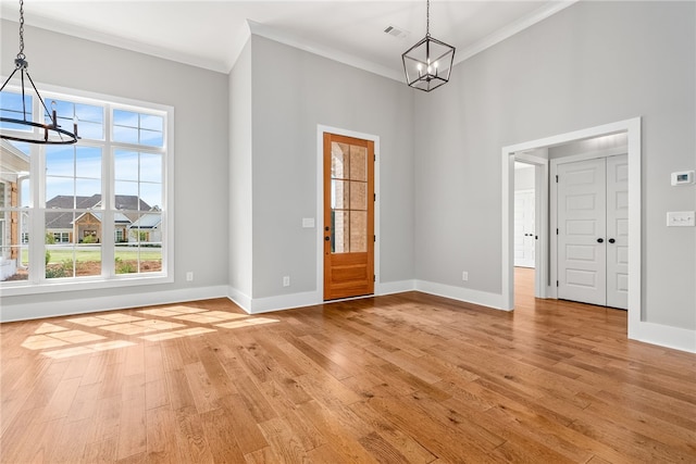 entryway featuring baseboards, visible vents, a notable chandelier, and light wood finished floors