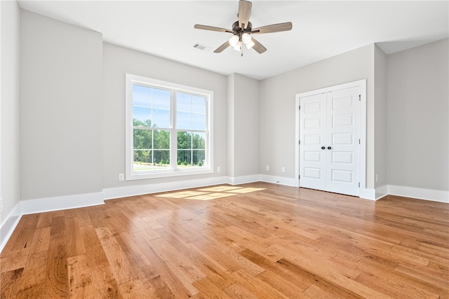 unfurnished bedroom featuring visible vents, ceiling fan, light wood-style flooring, and baseboards