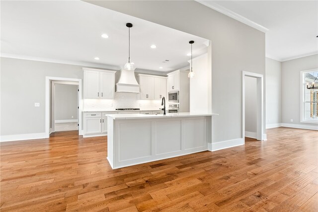 kitchen featuring crown molding, stainless steel appliances, light countertops, decorative backsplash, and premium range hood