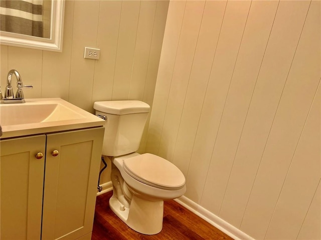 bathroom with toilet, wood finished floors, and vanity